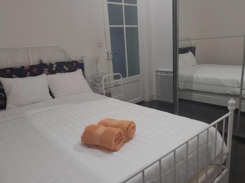 - un lit blanc avec une serviette dans l'établissement Les Palmiers NiceAirport, Beach200m, 2bedrooms, Wifi Optic, à Nice