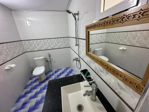 a bathroom with a sink and a toilet and a mirror at Villa MANSOURA in Driouch