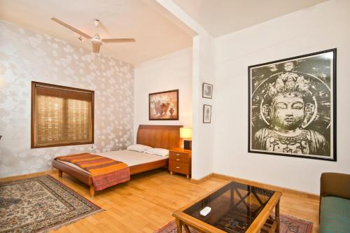 Habitación con cama, sofá y mesa. en Trendy Bed & Breakfast, en Nueva Delhi