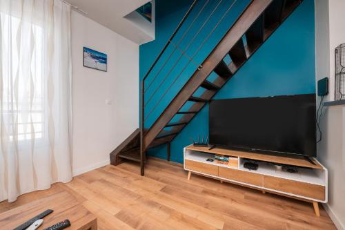 un salon avec une télévision à écran plat et un escalier dans l'établissement Lofoten - Îlots de Merville, à Lorient