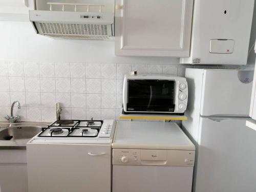 Il comprend une cuisine équipée d'un four micro-ondes et d'une cuisinière. dans l'établissement Coeur de ville appartement t3 pour 6 personnes N35, à La Grande Motte