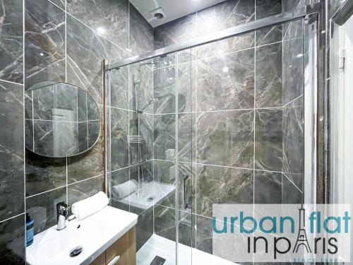une salle de bain avec une douche, un lavabo et un miroir dans l'établissement Urban Flat 63 - 3 Bedrooms Flat Champs-Elysees Mermoz, à Paris