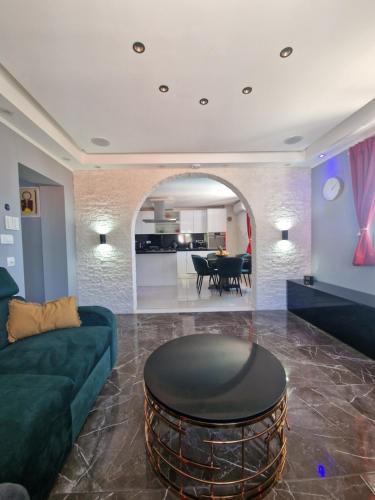 a living room with a couch and a table at Apartment Casa Lumina - 5 minutes to the airport and centar all private in Zvekovica