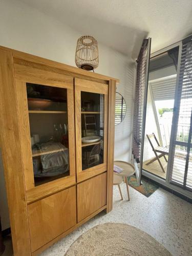 - un grand meuble en bois dans le salon dans l'établissement Quartier couchant Appartement studio pour 2 personnes N118, à La Grande Motte