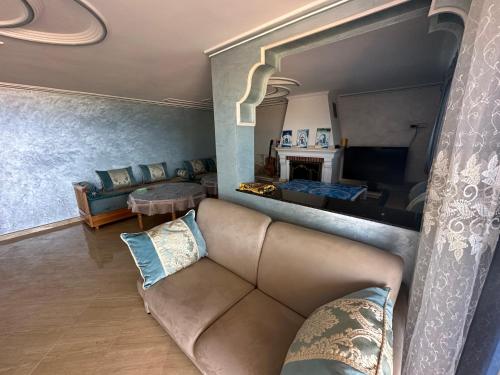 a living room with a couch and a table at Villa MANSOURA in Driouch