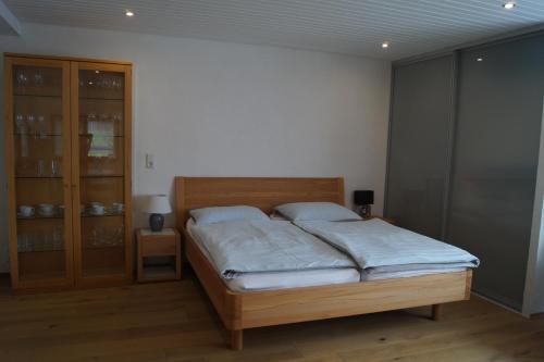 a bedroom with a bed and a glass cabinet at Ferienwohnungen Natürliches Wohnen in Beckingen