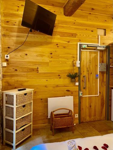 Cette chambre est dotée d'un mur en bois et d'une télévision murale. dans l'établissement Studio Julia, à Carcassonne