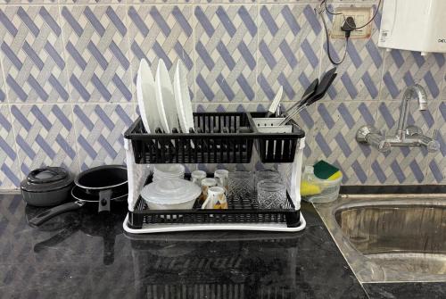 a tray of utensils on a counter next to a sink at Peaceful Studio With Kitchen & Terrace 301 in Patna