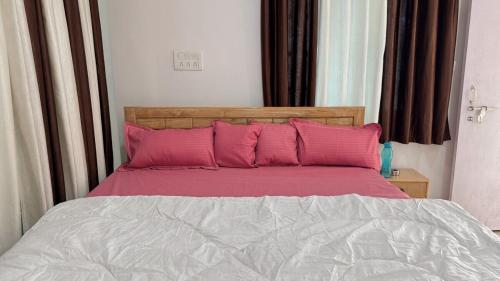 a bed with pink pillows in a bedroom at Peaceful Studio With Kitchen & Terrace 301 in Patna