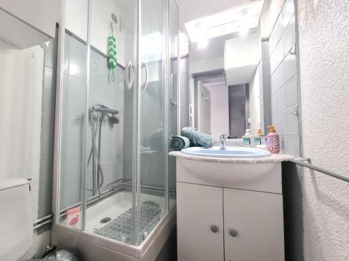 une salle de bain avec une douche en verre et un lavabo dans l'établissement Le Nid du lac 600m des plages, à Port-la-Nouvelle