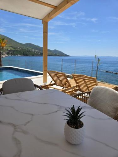 a table and chairs with a view of the ocean at Lavanda Mobile Homes & Villas in Orebić