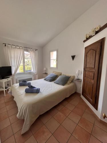 une chambre avec un grand lit et une télévision dans l'établissement Clos des Cassis - Maison d'Hôtes, à Villeneuve