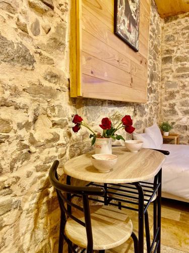 une petite table avec deux roses dessus dans l'établissement Studio Julia, à Carcassonne
