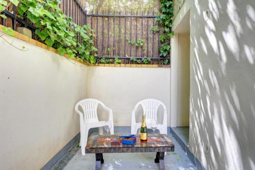 - 2 chaises et une table avec une bouteille de vin sur la terrasse dans l'établissement TBS 331 - Charming apartment in Ivry, à Ivry-sur-Seine