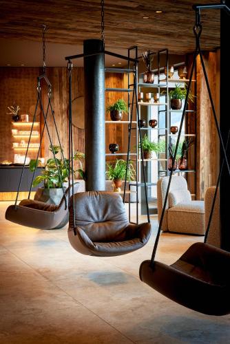 three swings in a room with potted plants at Der Böglerhof - pure nature spa resort in Alpbach