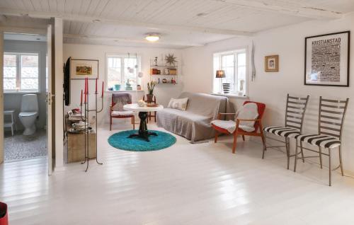 a living room with a table and chairs at Awesome Home In Östra Sönnarslöv in Östra Sönnarslöv