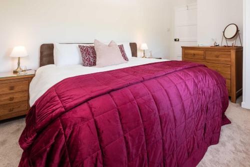 a bedroom with a large bed with a purple blanket at Melfort Village in Oban