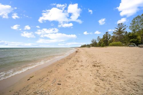 una spiaggia sabbiosa con l'oceano in una giornata nuvolosa di Spacious 4BR Lakefront Cottage - Perfect for Groups a Lincoln Junction