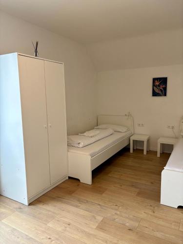ein weißes Schlafzimmer mit einem Bett und einem Schrank in der Unterkunft kleine und charmante Monteurs Unterkunft C in Karlsruhe