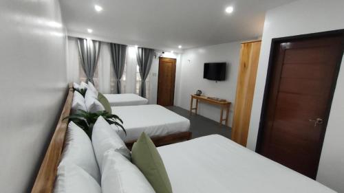 a hotel room with two beds and a couch at Ola De Baler Hotel in Baler