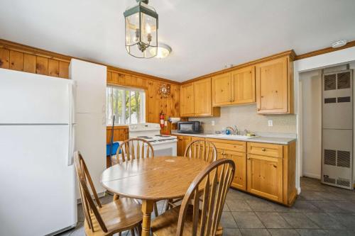 una cucina con un tavolo e un frigorifero bianco di 1BR Lakefront Cottage - Perfect for Two a Lincoln Junction