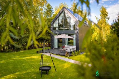 a glass house with a swing in the yard at Dom w Starkowie, Sauna i Balia in Starków