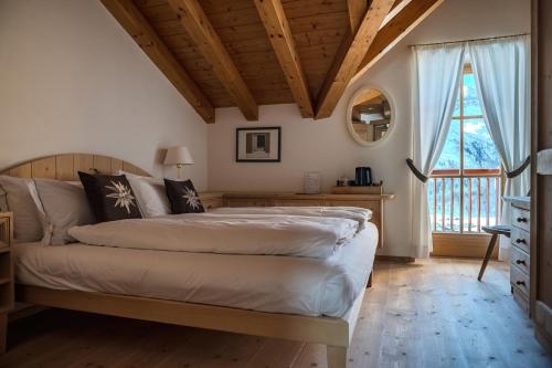 una camera da letto con un letto e una grande finestra di Chalet Cima Uomo a Passo San Pellegrino