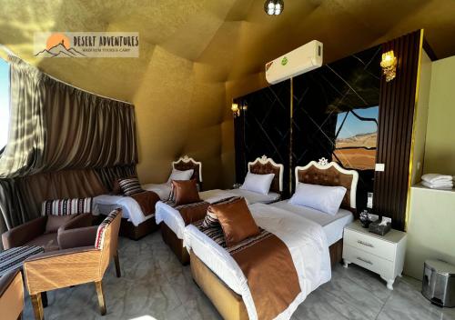 a room with three beds and a couch at Wadi Rum Desert Adventures in Wadi Rum