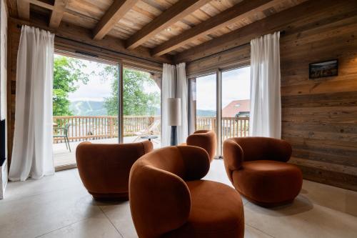 a living room with chairs and a large window at Chalet Le Cocon des Marmottes in Gérardmer