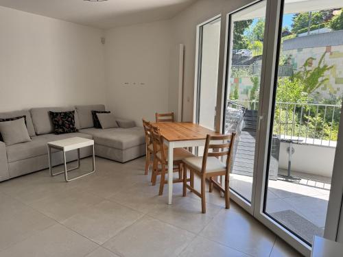 un salon avec une table, des chaises et un canapé dans l'établissement Le Palmier, à Annecy