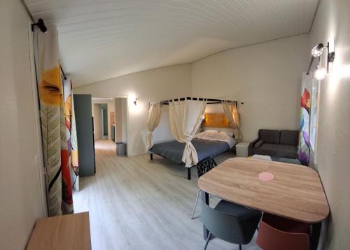 Cette petite chambre comprend un canapé et une table. dans l'établissement Cottage Confort 1 Ch, à Mareuil-sur-Lay