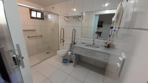 a bathroom with a sink and a toilet and a mirror at Pousada Guaratiba in Prado