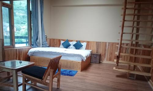 PalchānShree Dev Narayan Hotel的一间卧室配有一张带梯子和桌子的床