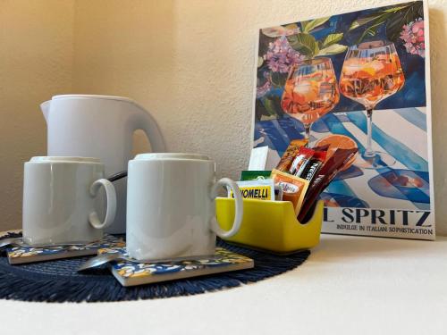 two coffee mugs sitting on a table next to a box at Rooms Hub Costa d'Amalfi - Vietri sul Mare in Vietri sul Mare