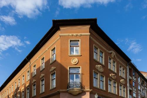 a brown building with a clock on the side of it at Hotel Pannonia in Miskolc