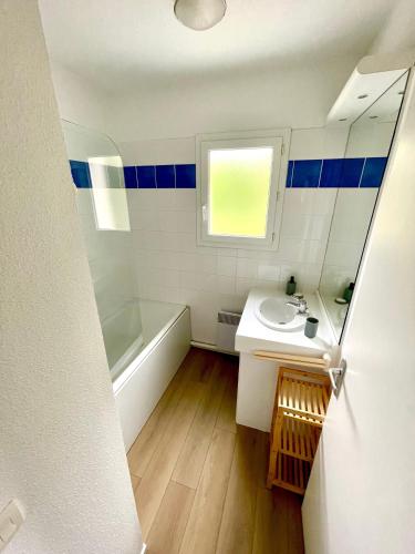 une salle de bain avec un lavabo, une baignoire et un miroir dans l'établissement Villa Naiades, à Soulac-sur-Mer