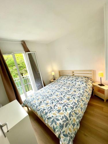 une chambre avec un lit et une grande fenêtre dans l'établissement Villa Naiades, à Soulac-sur-Mer