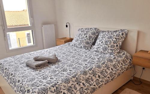 une chambre avec un lit avec une couette noire et blanche dans l'établissement Paisible duplex 6 personnes, à Gujan-Mestras