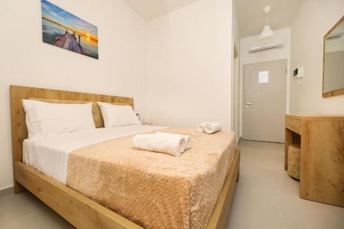 GjilekにあるSantorini Residence, Drymades Dhermiのベッドとタオル2枚のある寝室