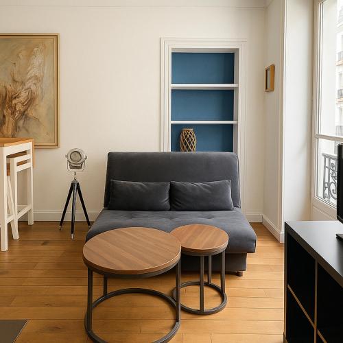 un salon avec un canapé et deux tables dans l'établissement CHAMPS DE MARS - SUFFREN, à Paris