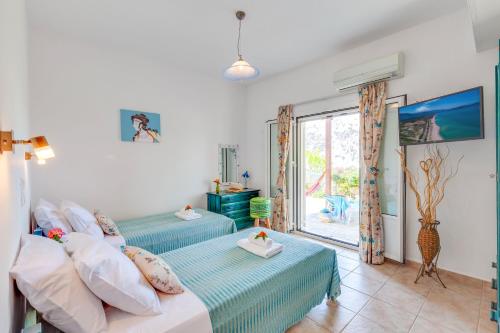 a bedroom with two beds and a window at Kallisti Artemis in Kávallos