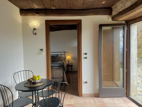 a room with a table and chairs and a glass door at Perletto in Olmo Gentile