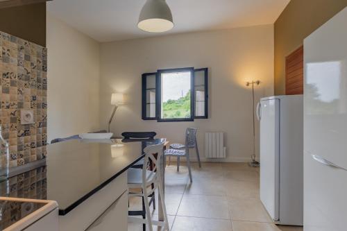 a kitchen with a refrigerator and a table and chairs at Beau gite avec couloir de nage in Le Garn