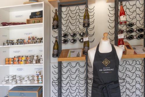 a shop with apron and wine bottles on shelves at Beau gite avec couloir de nage in Le Garn