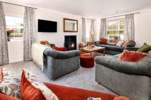 a living room with two couches and a fireplace at Melfort Village in Oban
