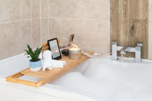 a bathtub with a wooden tray with towels and candles at Melfort Village in Oban