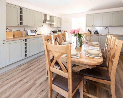 a kitchen with a wooden table with a vase of flowers at Melfort Village in Oban