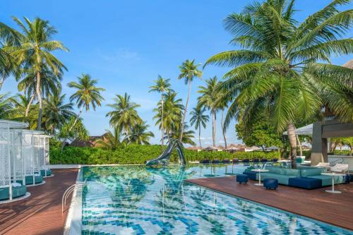 a pool at the resort with palm trees at W Maldives in Fesdu Island