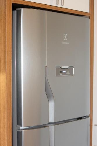a stainless steel refrigerator with a drawer in a kitchen at Studio 3 min from the subway - Complete and well located in Sao Paulo