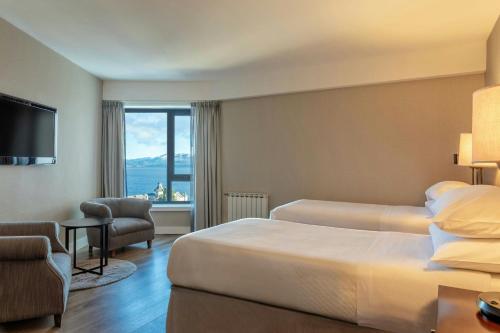 a hotel room with two beds and a large window at Sheraton Bariloche Hotel in San Carlos de Bariloche
